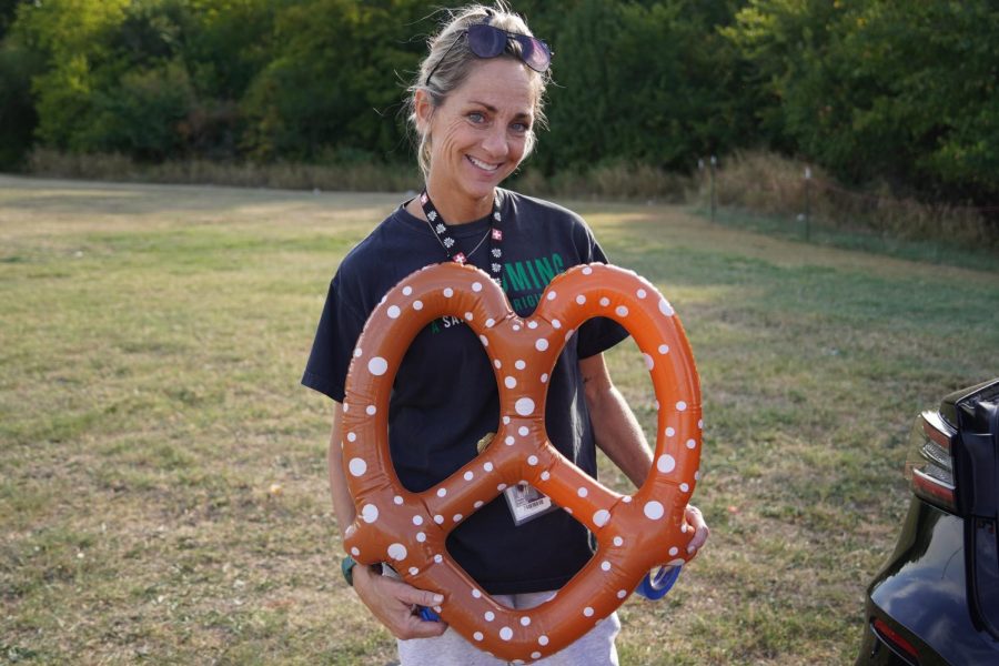 Mrs. White the sponsor of the german club holding an inflatable pretzel.