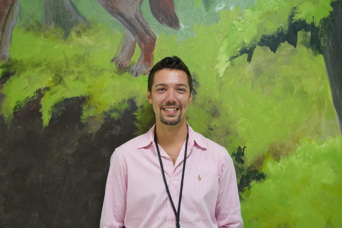 Jared Bush smiles in front of the F Hall mural.