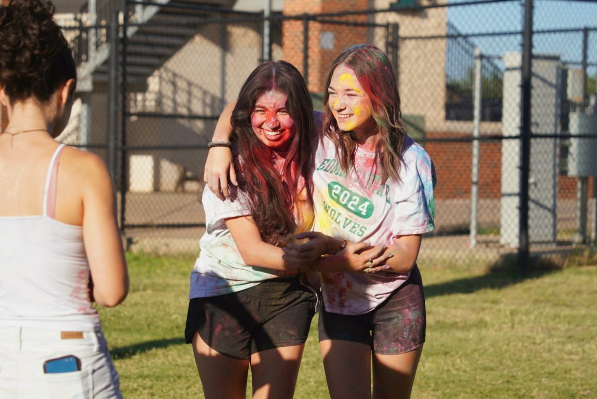 Seniors Celeste Martinez and Makenna Fox hugging after throwing powder on each other