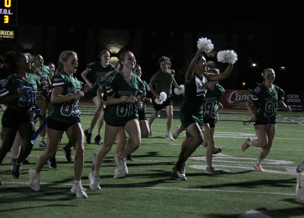 Senior girls running to the sidelines before kickoff.