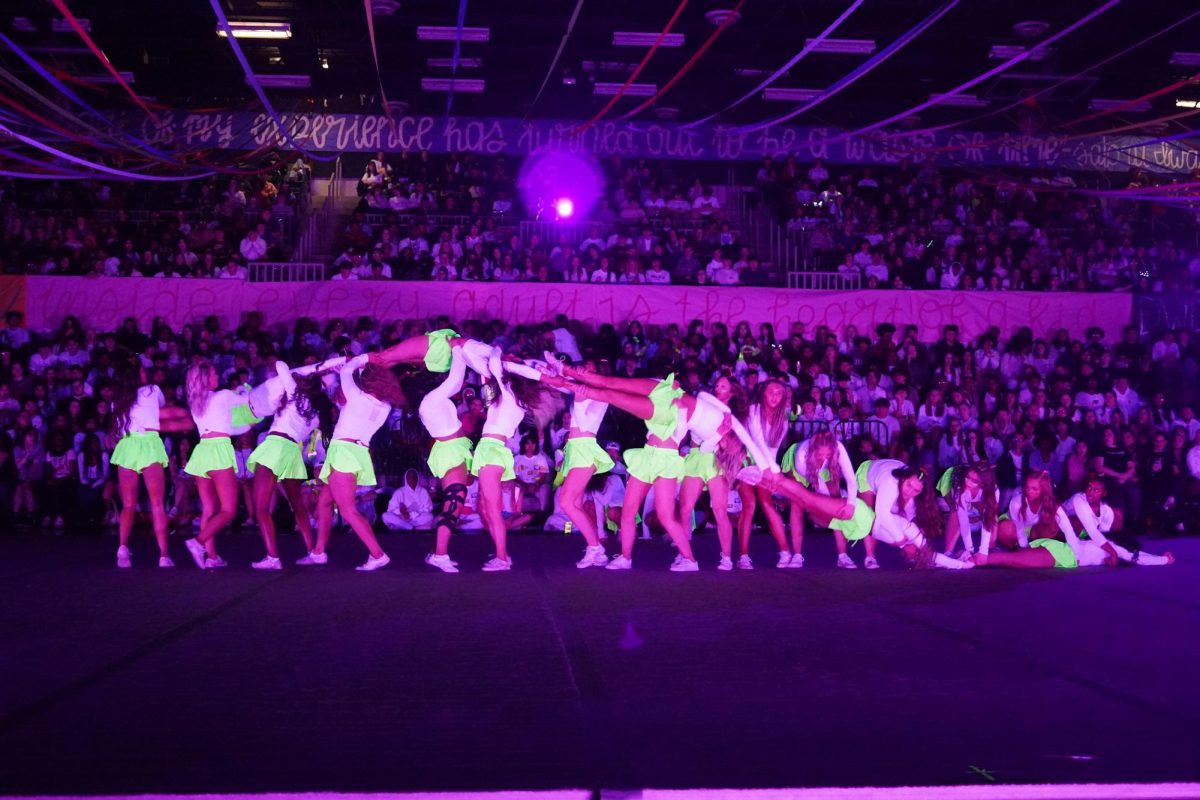 Cheer doing a wave during their Blacklight dance. 