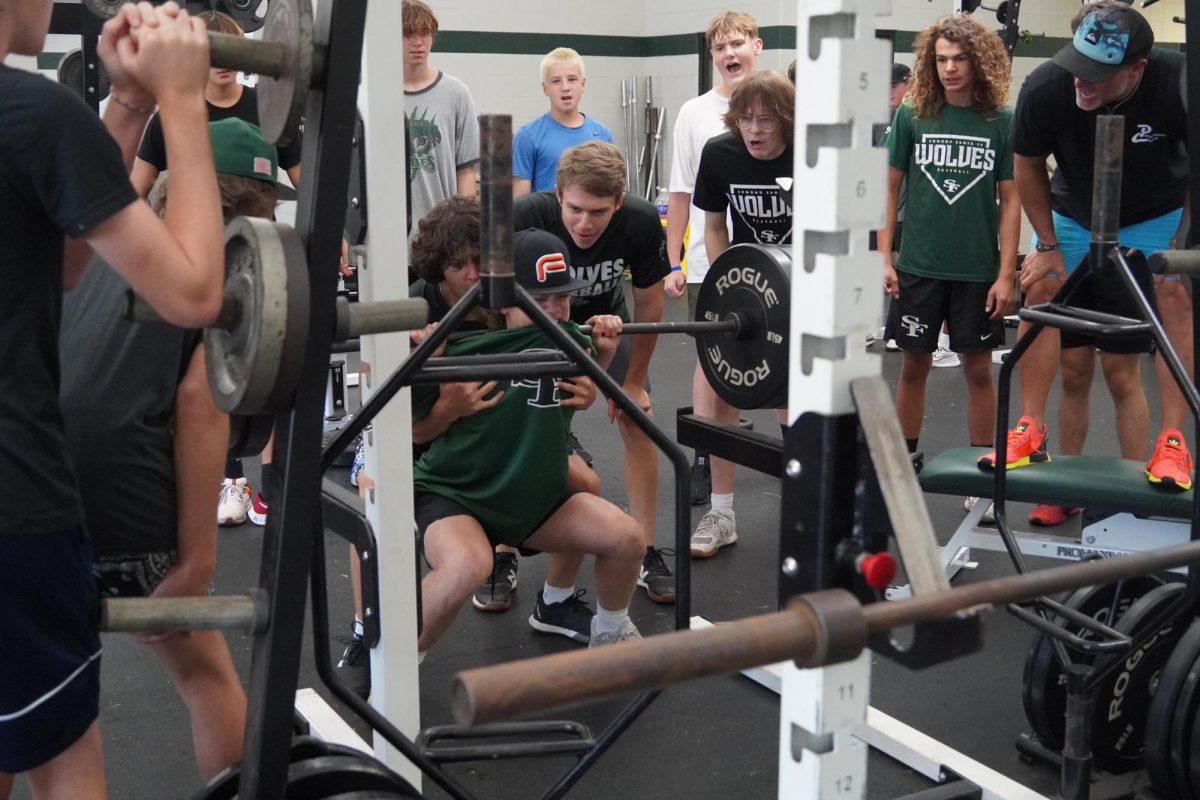 Baseball hyping up their teammate while he maxes on squat. 