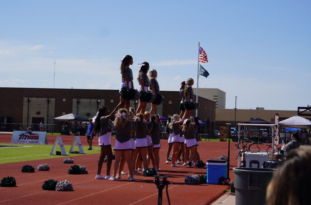 Santa Fe cheer team preforming stunts at Wolf Wars.