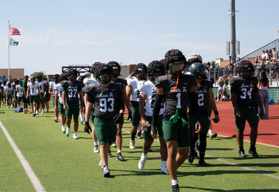 the Santa Fe Football team stepping out on the field getting ready to go up against themselves for the wolf wars fundraiser.