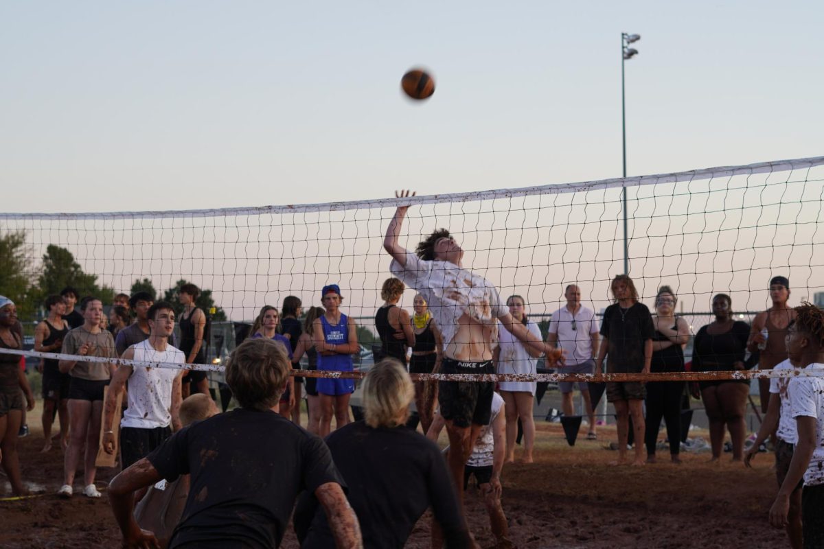 Eli Stowe spiking the ball at mud volleyball.