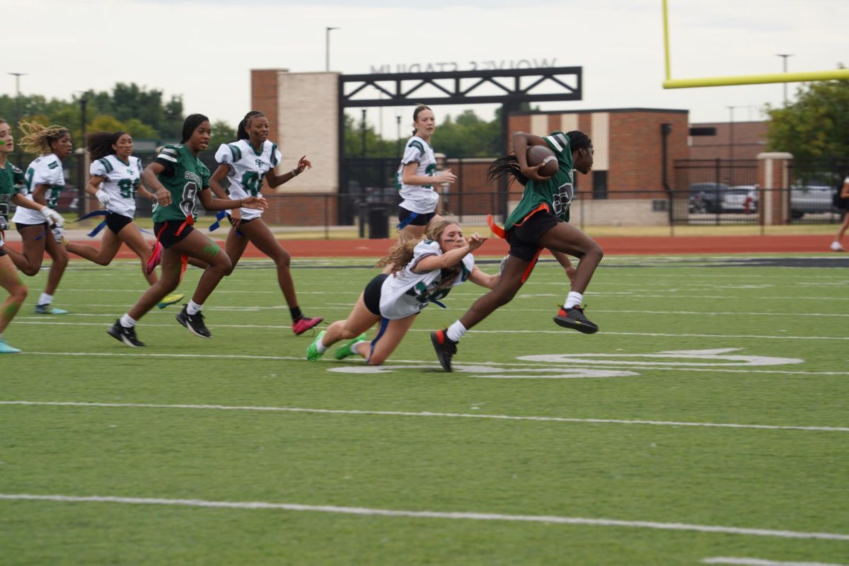 Maddy McMillin reaching for a sophomore’s flag. 