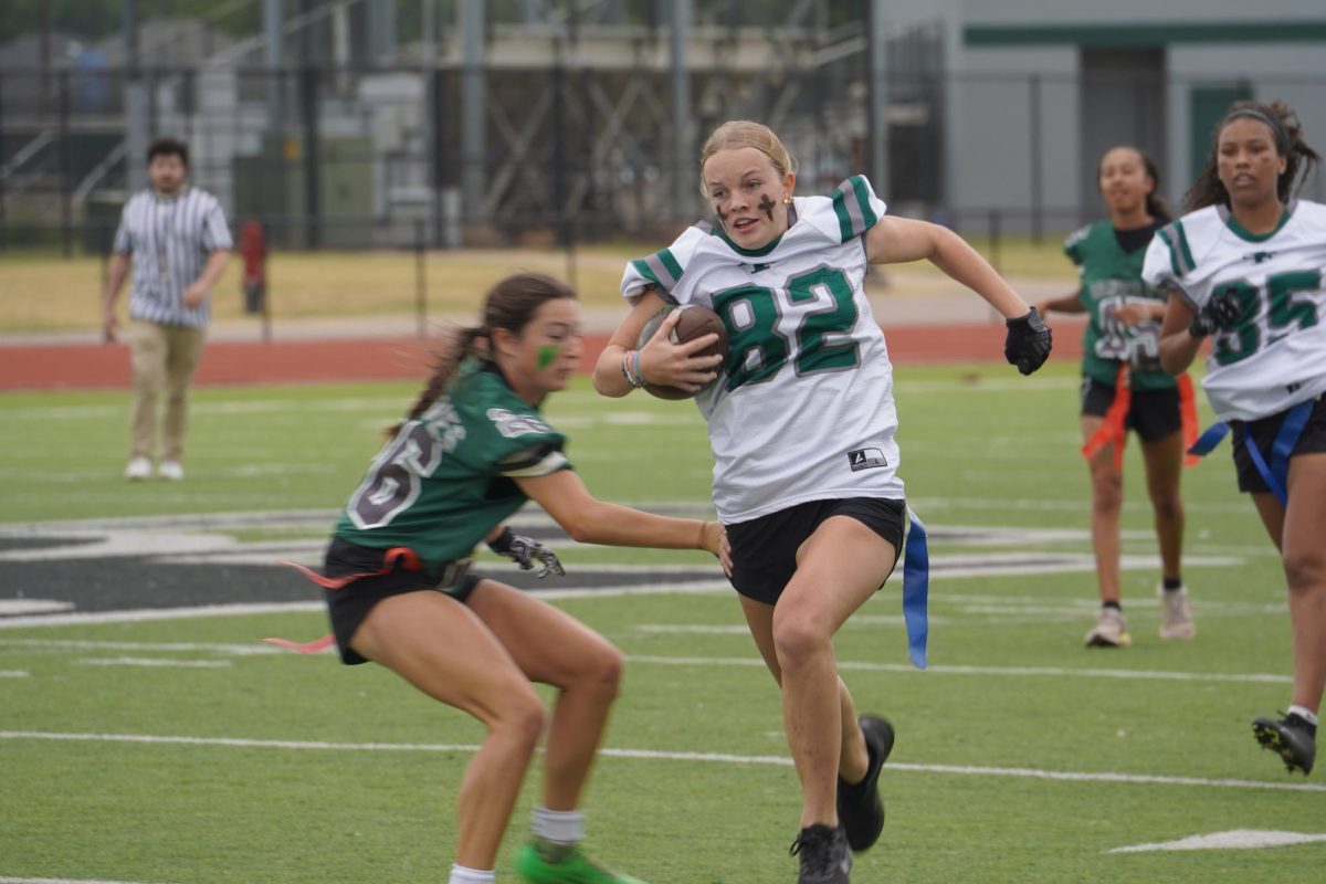 A junior running down the field with the ball. 