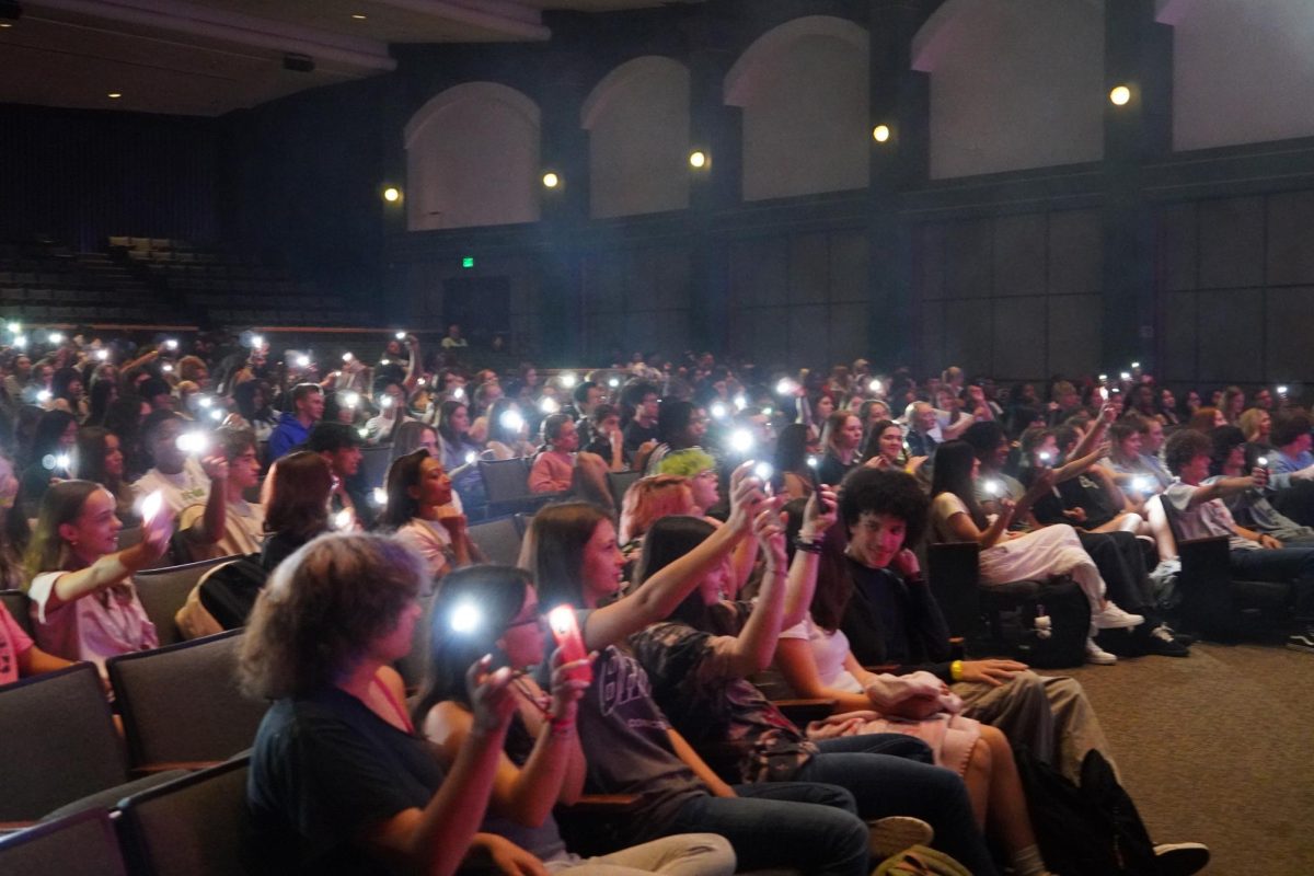 Students use their flashlights in appreciation for Ian Jenkins and Hiba Sheikh's performance of "Die With A Smile" by Bruno Mars and Lady Gaga.