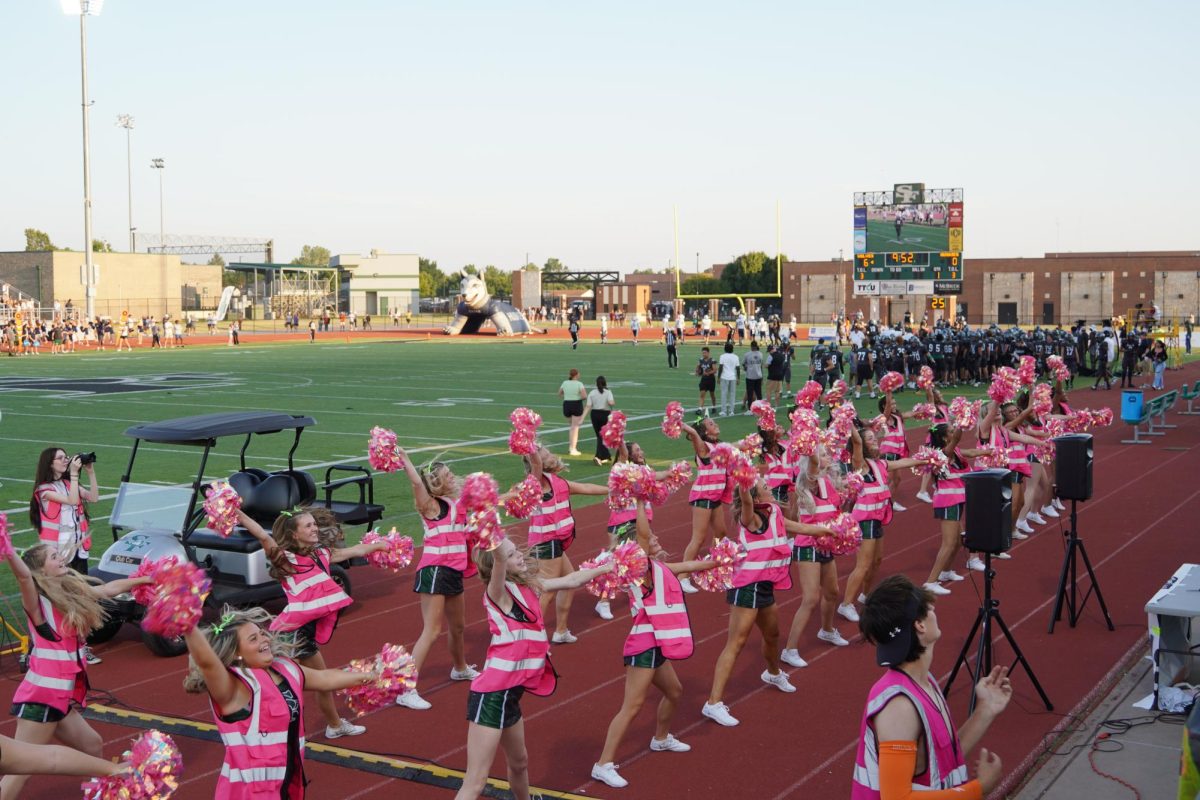 Pom team dancing to band.