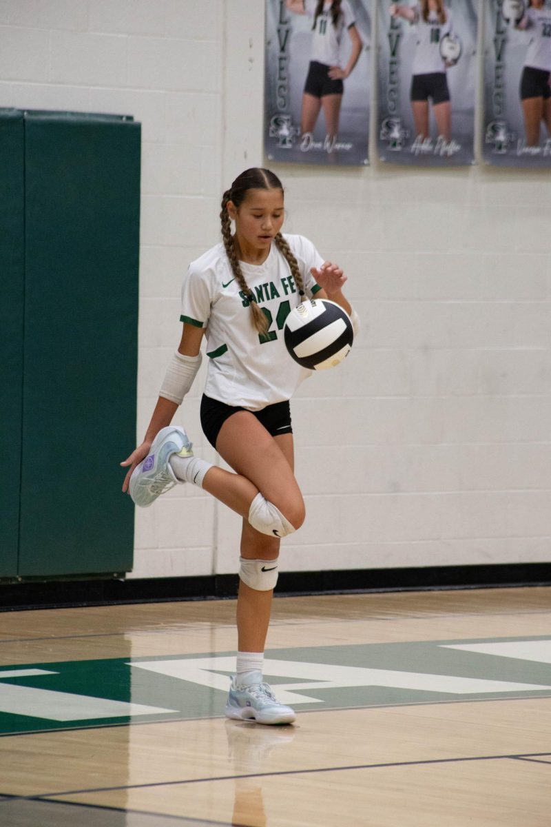 Madde Factor wiping her shoes before serving the ball.