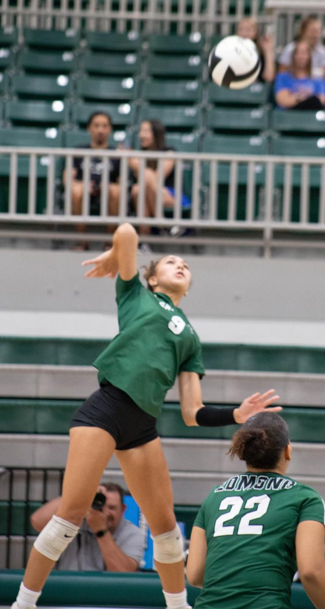 Nayeli Crawford jumping high in the air to hit the ball back to the enemy team.