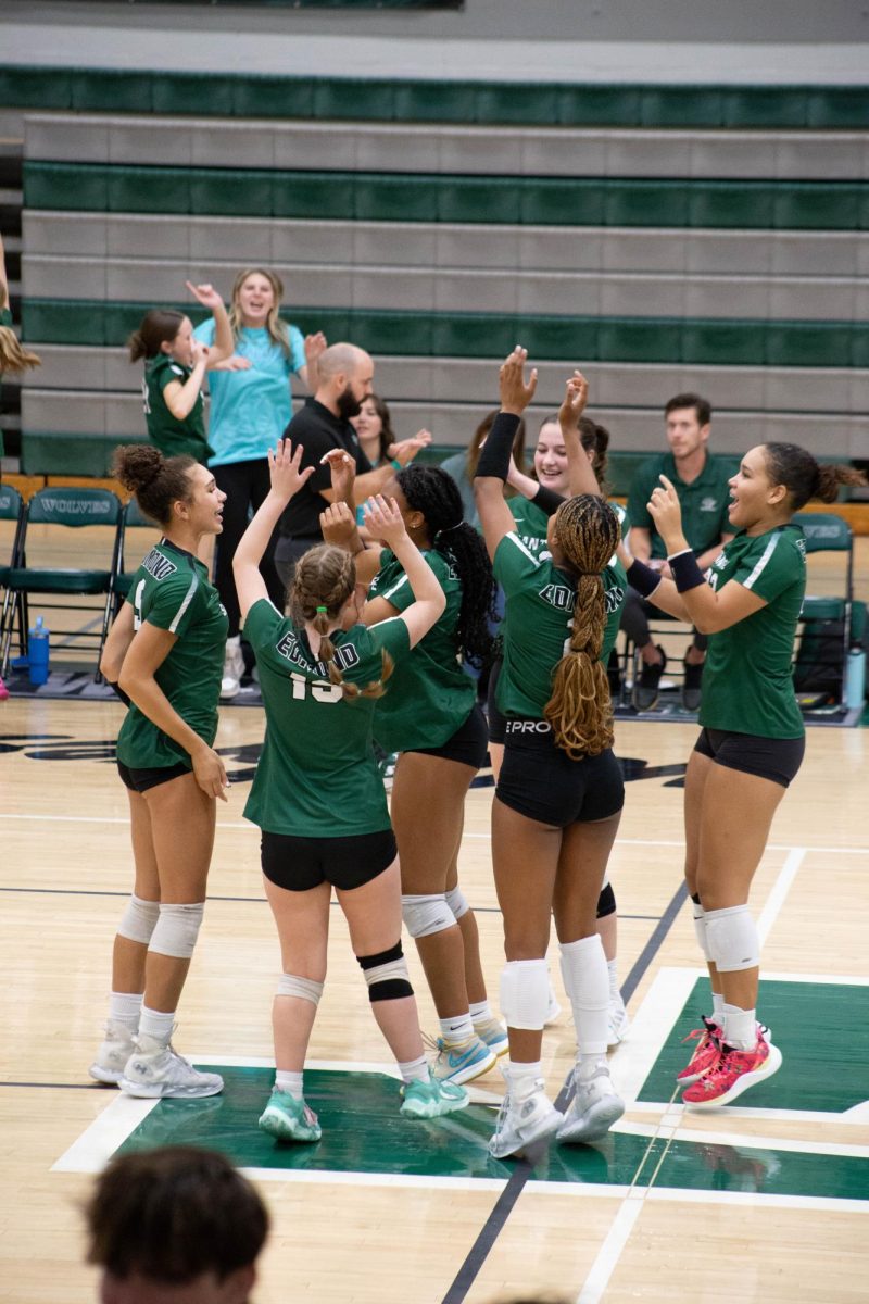 Varsity volleyball team celebrating together.