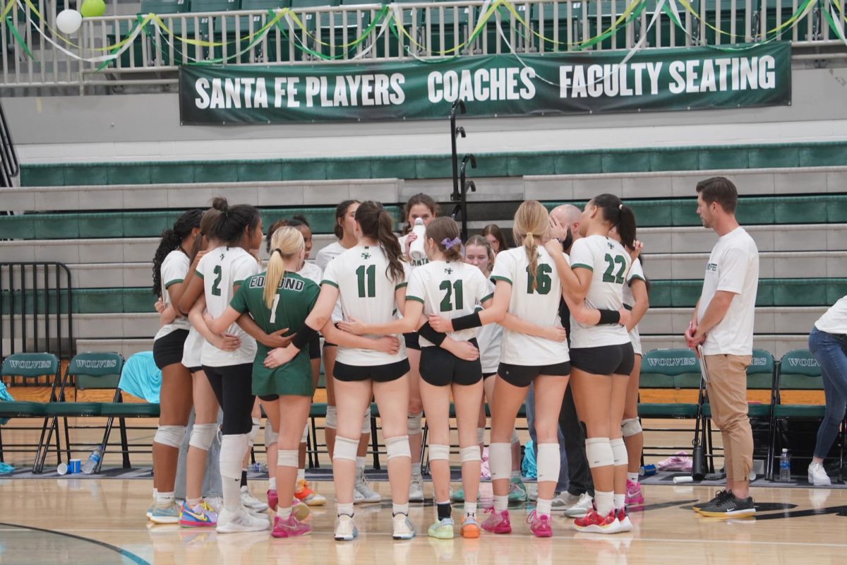 Varsity volleyball talking in the huddle.