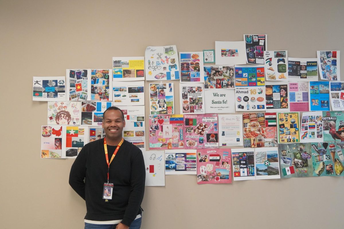 Brandon Williams stands in front of students projects on display. 