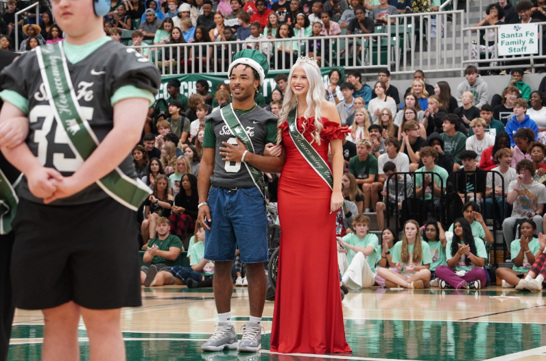 Homecoming King Demarius Robinson and Queen Leah Smith stand smiling after being crowned. 