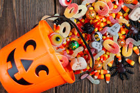 Halloween candy being spilled out of a pumpkin bucket