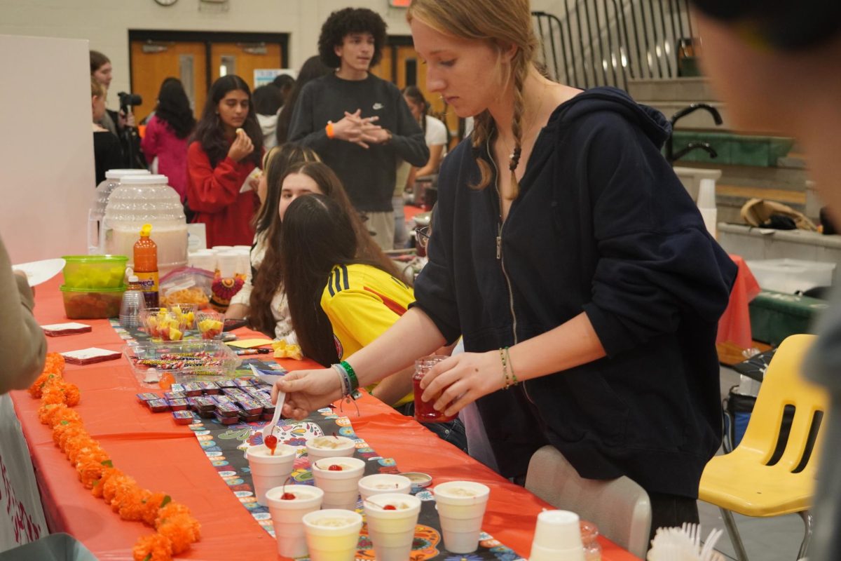 Junior Allida Pauson preparing food at the Spanish Club booth.