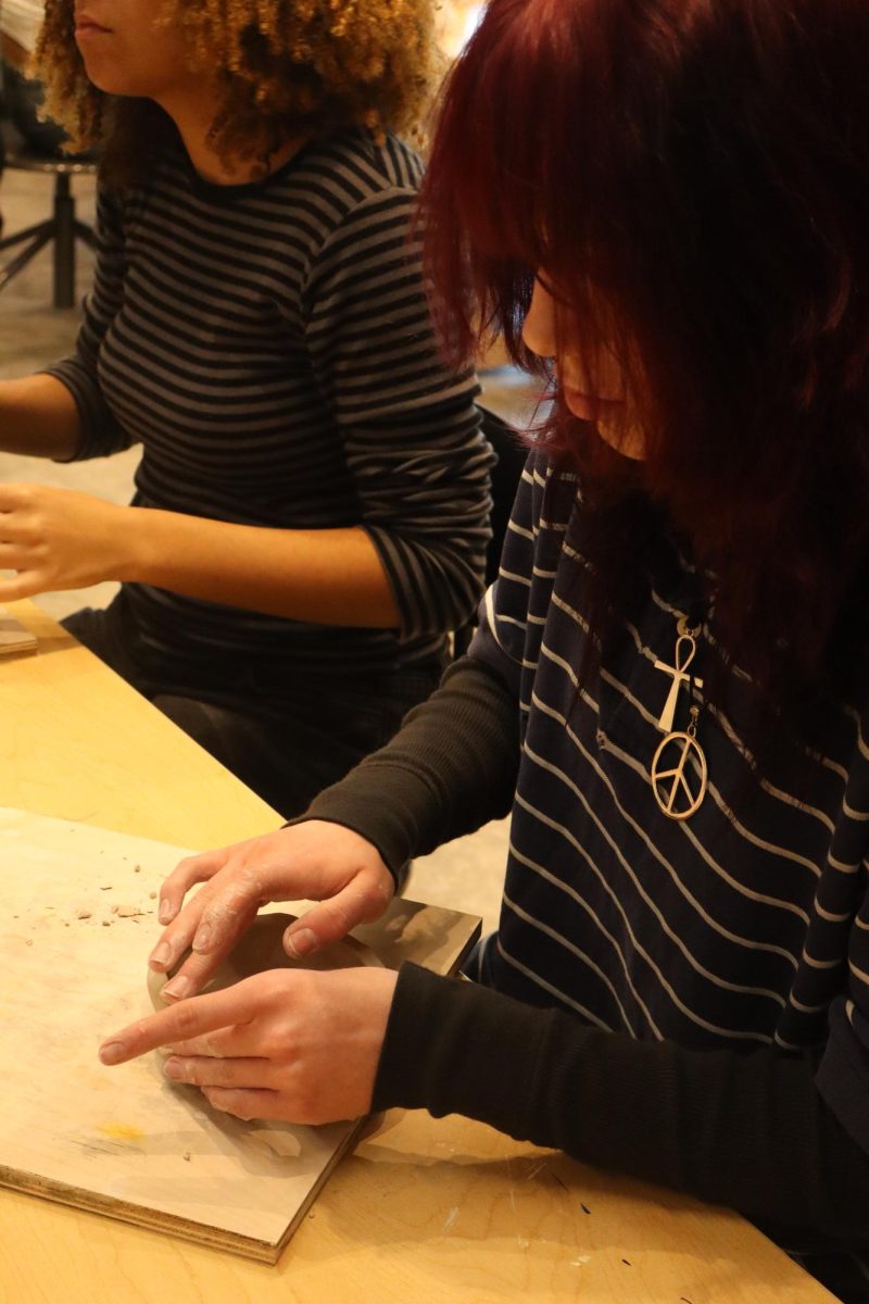 Senior Kate Morgan working pinch pot project in ceramics.