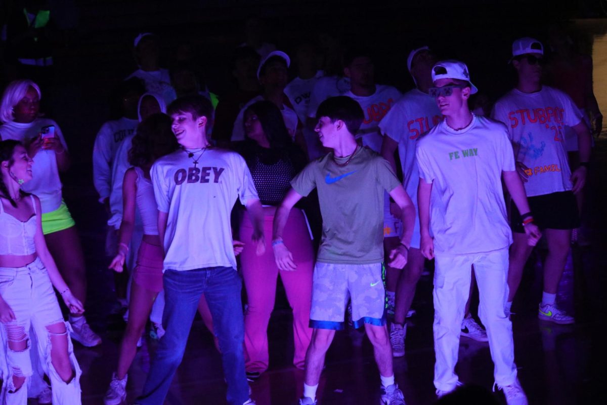 Students Brett Hamilton, Pierce Mote and Ian Jenkins dancing at the blacklight dance.