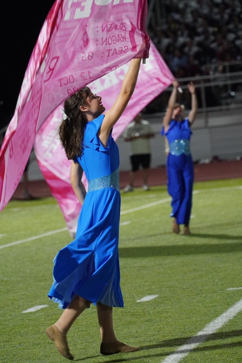 Color guard member Harper Culley waving her flag.