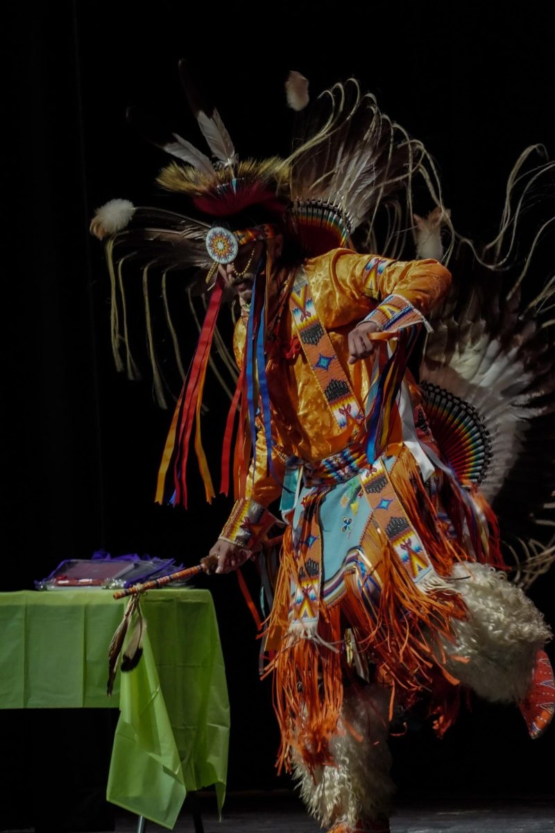 A person dressed in Native American attire dancing. 
