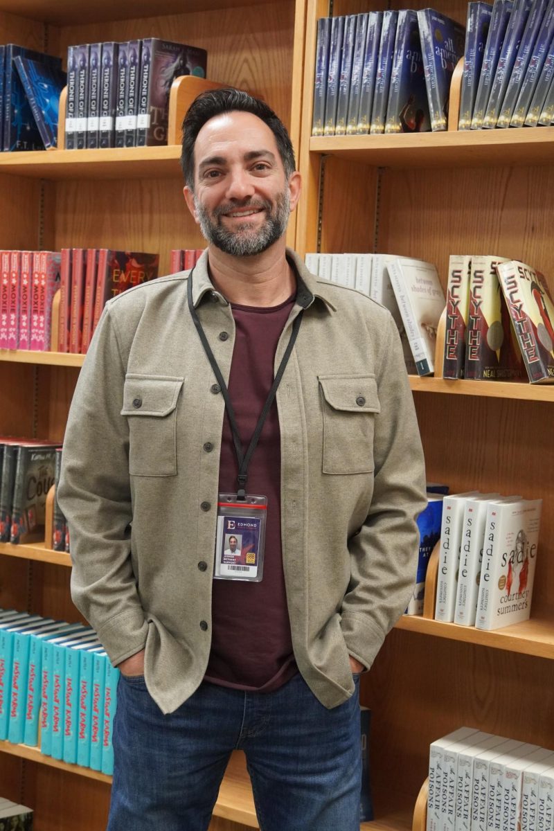 Josh Bethany posing in front of a bookcase.