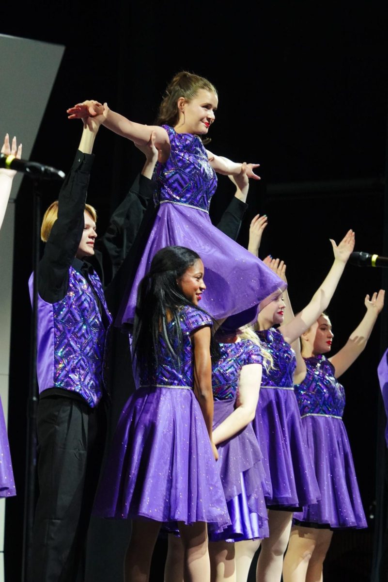 Junior Reid DeGroot and senior Alanda Pollard lifting senior Alyssa Hargiss in "Electricity."