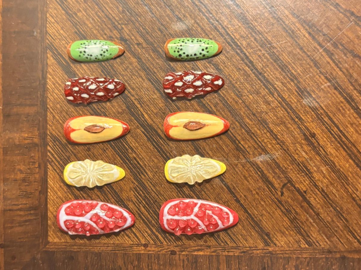 A press-on nail set of fruits including: grapefruit, lemon, peach, strawberry and kiwi. 