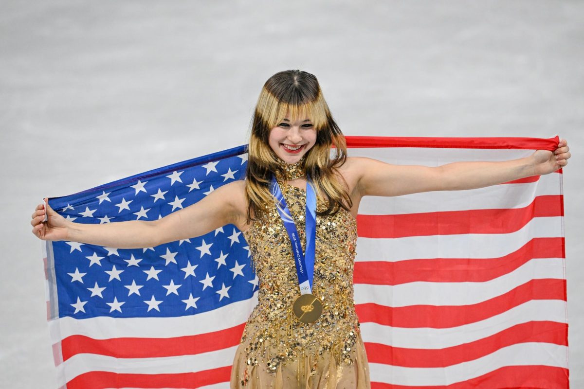 Liu posing with the American flag after winning a gold medal at the 2026 Winter Olympics.