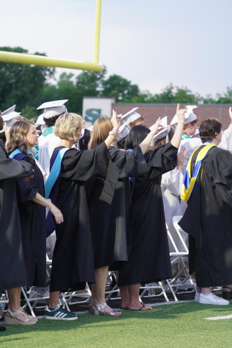 Santa Fe teachers and valedictorians doing wolf signs after the national anthem.